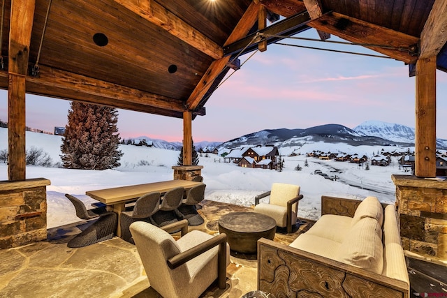 snow covered patio with a mountain view