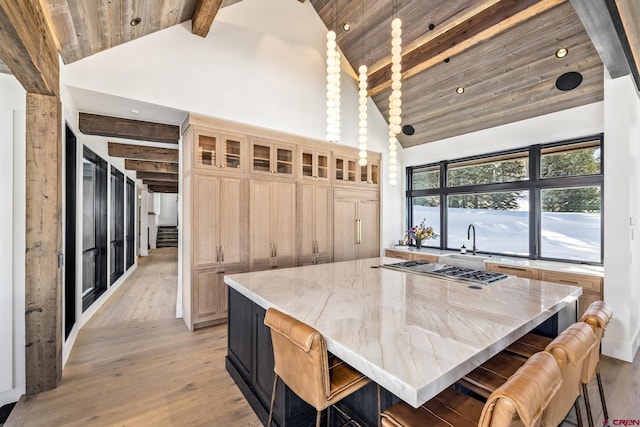 kitchen featuring a breakfast bar, wooden ceiling, stainless steel gas cooktop, and a spacious island