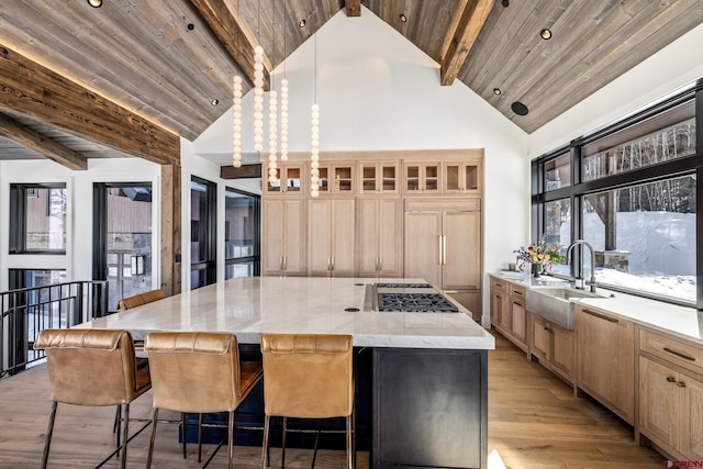 kitchen featuring a large island, paneled built in fridge, sink, and wooden ceiling