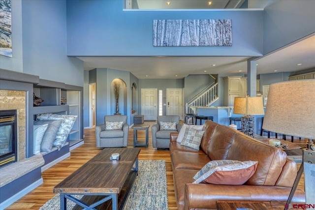 living room with light hardwood / wood-style flooring and a high ceiling