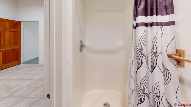 bathroom with curtained shower and tile patterned floors