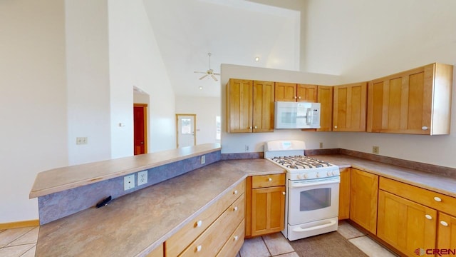 kitchen featuring high vaulted ceiling, light tile patterned floors, ceiling fan, kitchen peninsula, and white appliances