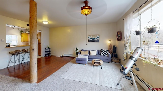 living room featuring a baseboard heating unit and hardwood / wood-style floors