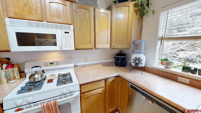 kitchen featuring white appliances and light brown cabinets