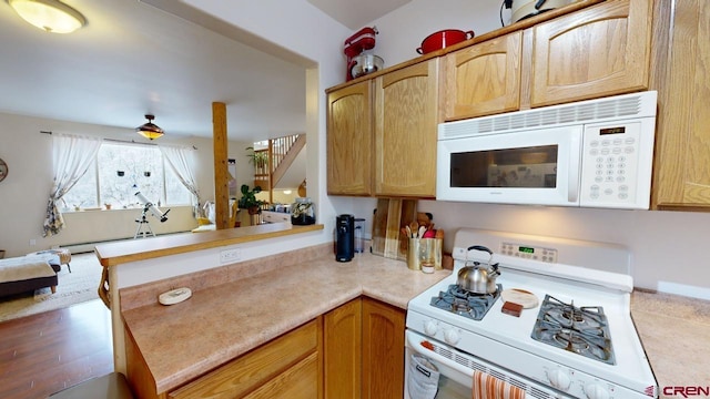 kitchen featuring white appliances and kitchen peninsula