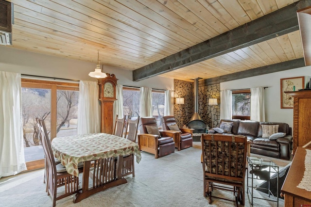 dining room with wood ceiling, light colored carpet, beamed ceiling, and a wood stove