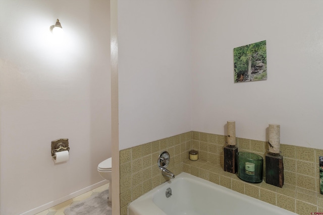 bathroom featuring tile patterned floors, toilet, and a bath