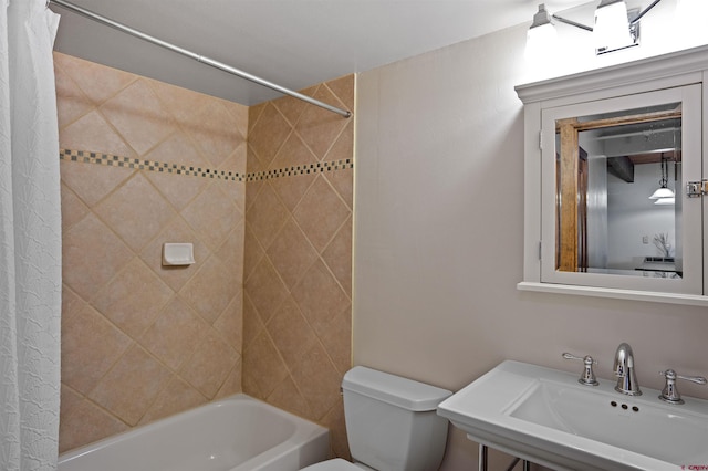 full bathroom featuring tiled shower / bath, toilet, and sink