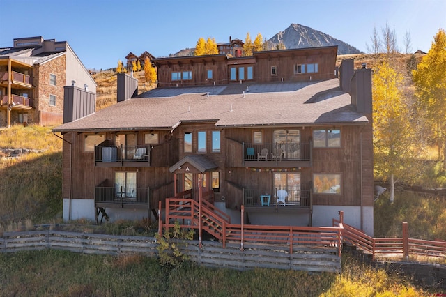 rear view of property featuring a mountain view and a balcony