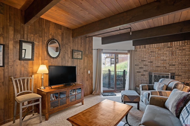 carpeted living room featuring beamed ceiling, a fireplace, wooden walls, and wooden ceiling