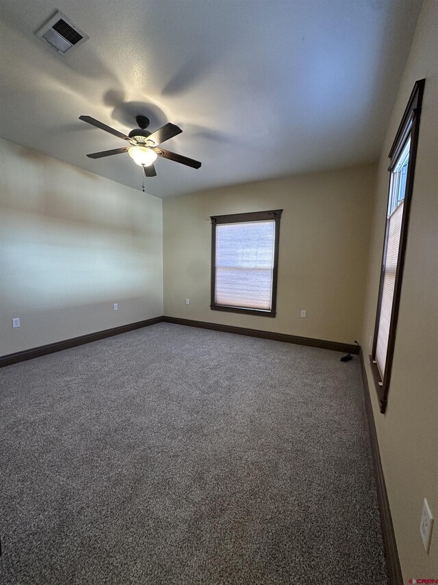 unfurnished room featuring ceiling fan, a healthy amount of sunlight, and carpet flooring