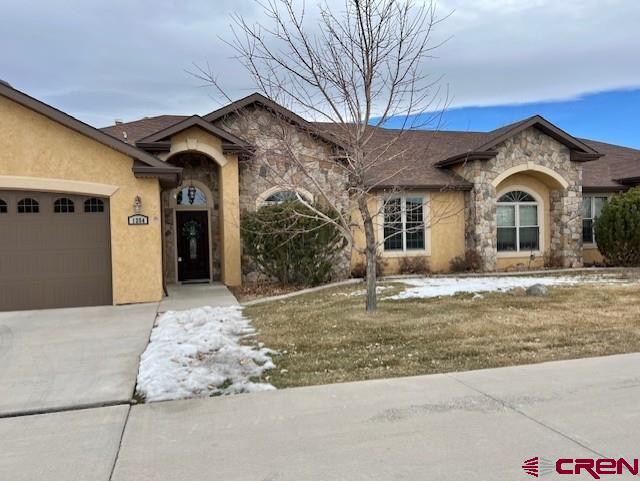 ranch-style home with a garage and a front yard