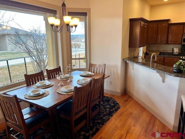 dining area with plenty of natural light, a chandelier, and light hardwood / wood-style floors