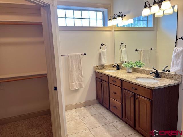 bathroom with vanity, a notable chandelier, and tile patterned flooring