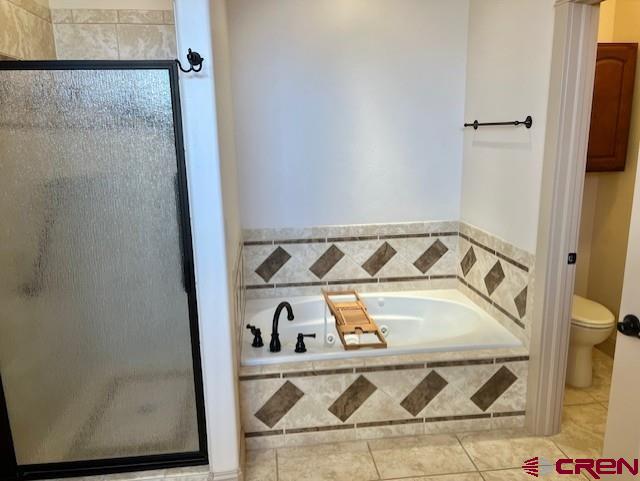 bathroom with shower with separate bathtub, tile patterned floors, and toilet