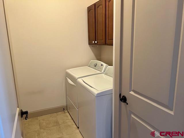 laundry room featuring cabinets and washing machine and clothes dryer