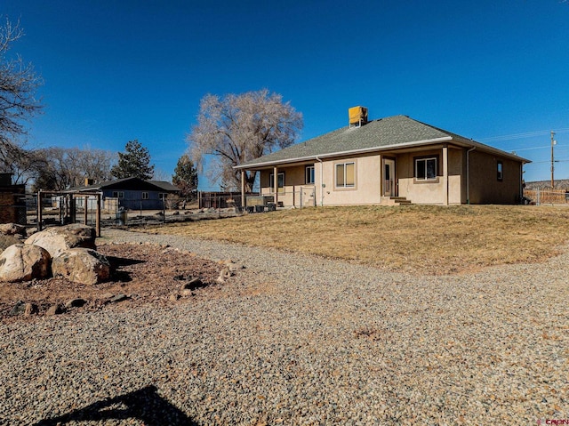 back of house featuring a carport and a yard