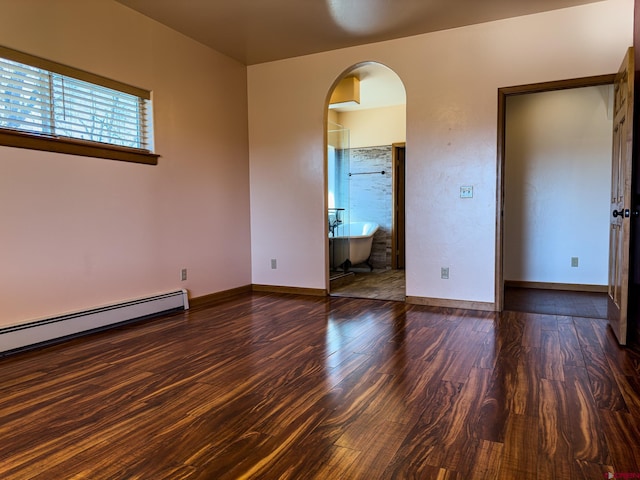 spare room with a baseboard radiator and dark hardwood / wood-style flooring