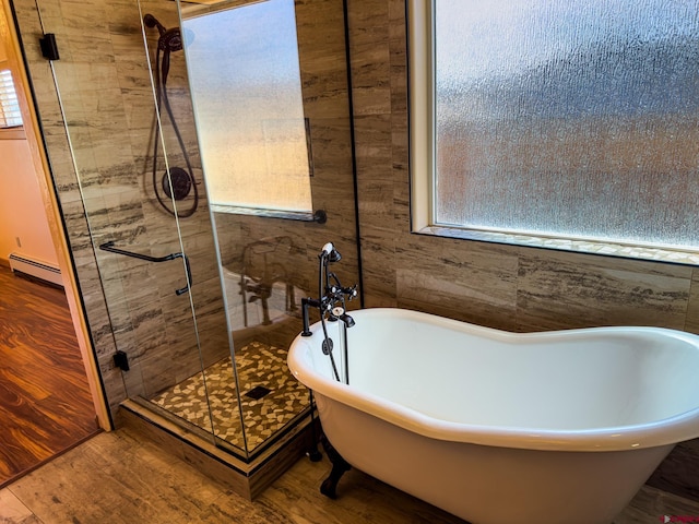 bathroom featuring baseboard heating, shower with separate bathtub, and hardwood / wood-style flooring