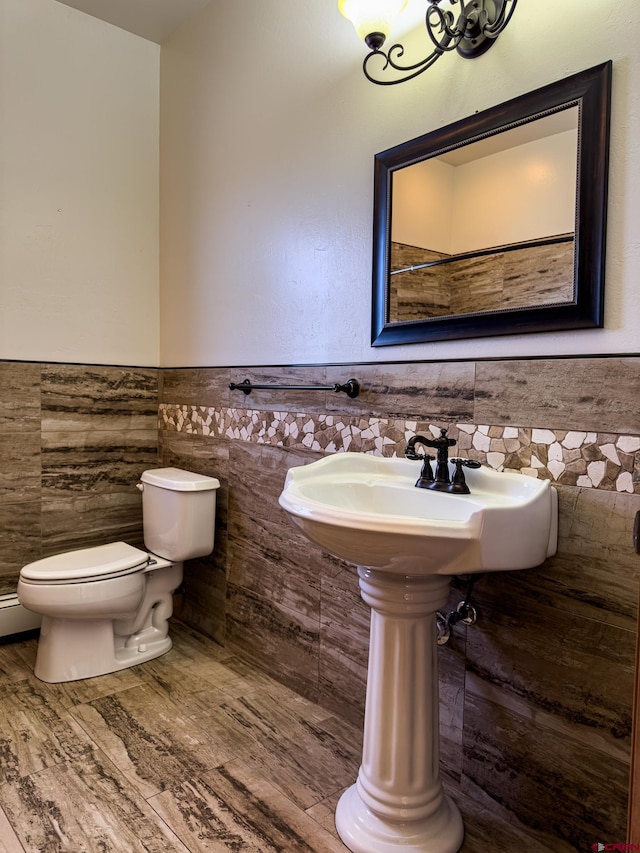 bathroom with tile walls, hardwood / wood-style flooring, and toilet