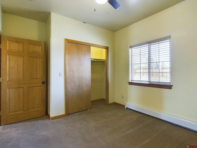 unfurnished bedroom featuring baseboard heating, ceiling fan, carpet flooring, and a closet