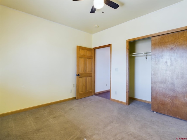 unfurnished bedroom featuring ceiling fan, light colored carpet, and a closet