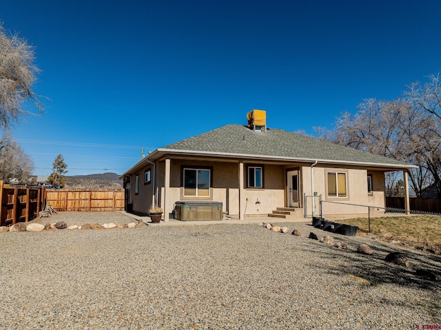 back of property featuring a hot tub and cooling unit