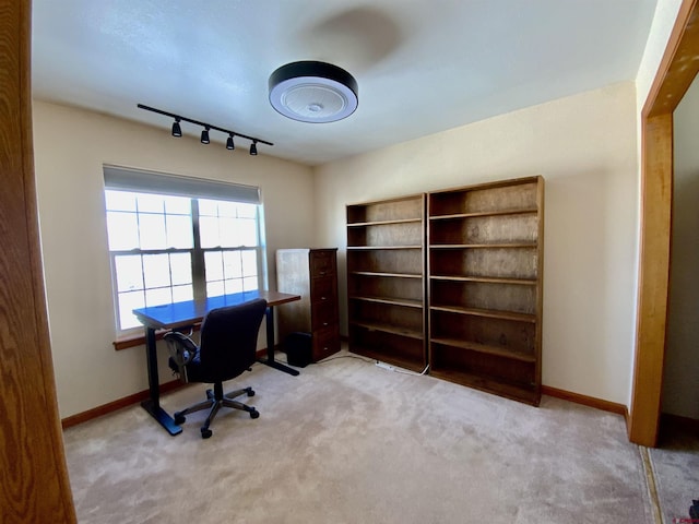 carpeted office featuring rail lighting