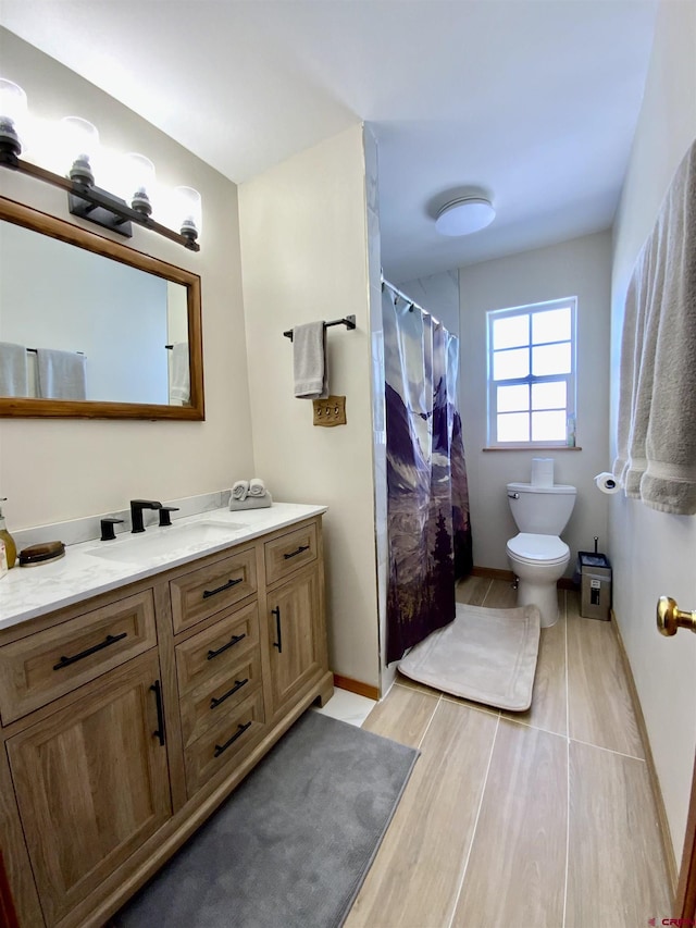 bathroom with vanity, toilet, and hardwood / wood-style floors