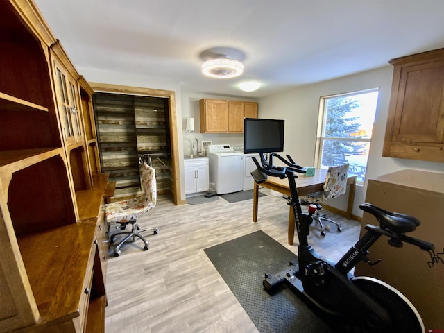 exercise area with sink, washer and clothes dryer, and light hardwood / wood-style floors