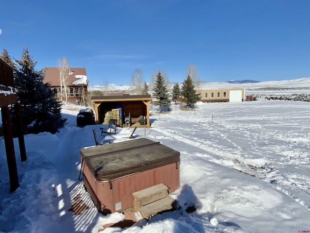 snowy yard featuring a hot tub