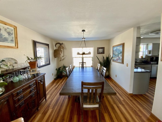 dining room with a textured ceiling, dark hardwood / wood-style floors, and a chandelier