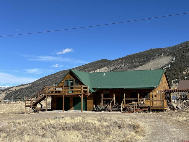 exterior space with a garage and a deck with mountain view