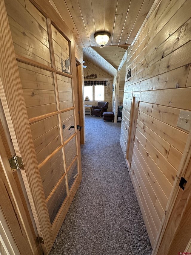 hallway with lofted ceiling, carpet floors, wooden ceiling, and wood walls