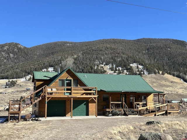 log-style house featuring a mountain view, a garage, and covered porch