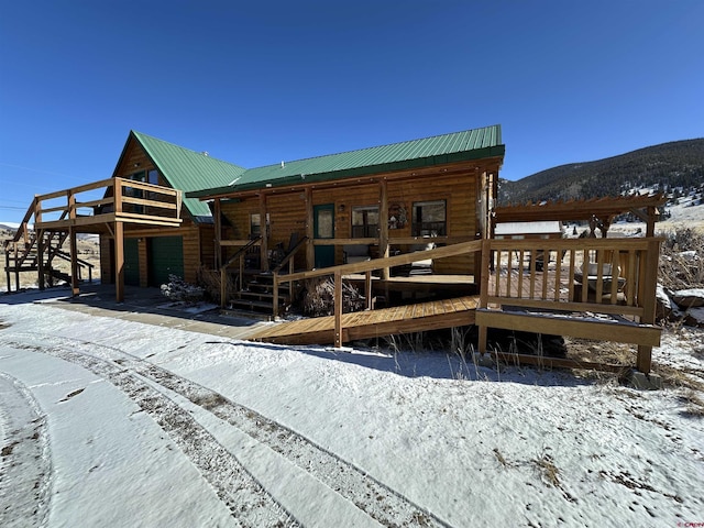 snow covered house featuring a mountain view