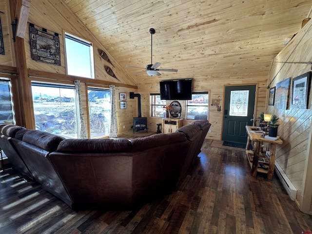 living room featuring high vaulted ceiling, wood walls, a wood stove, wood ceiling, and dark wood-type flooring