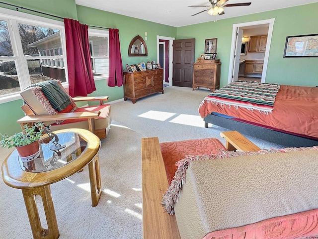 bedroom with ceiling fan, light colored carpet, and connected bathroom