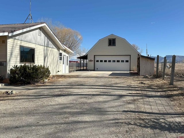 view of side of property with an outbuilding, a garage, and a carport