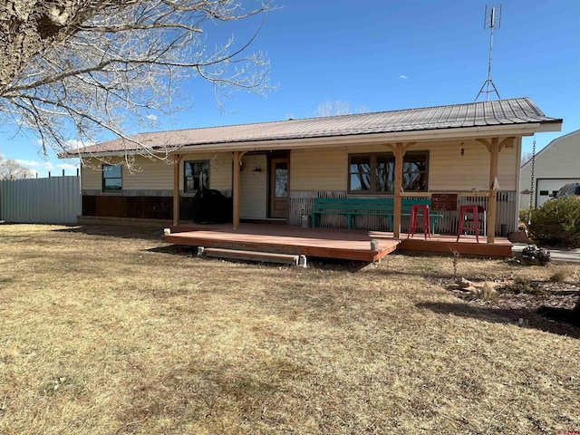 rear view of property featuring a yard and a deck