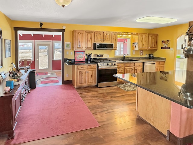 kitchen featuring sink, stainless steel appliances, light hardwood / wood-style floors, and a healthy amount of sunlight