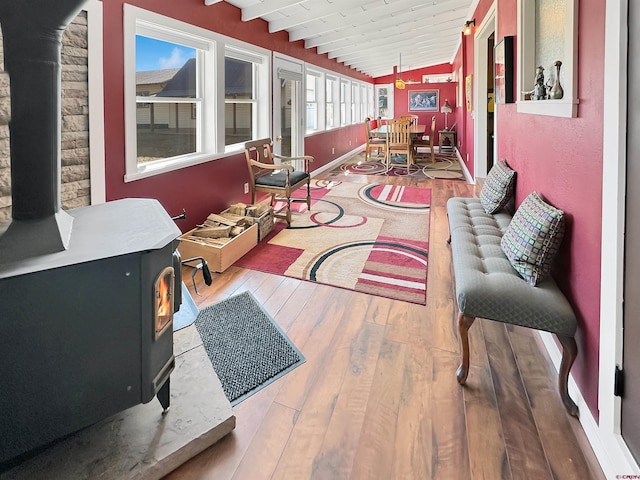 interior space with lofted ceiling with beams, a wood stove, and wooden ceiling