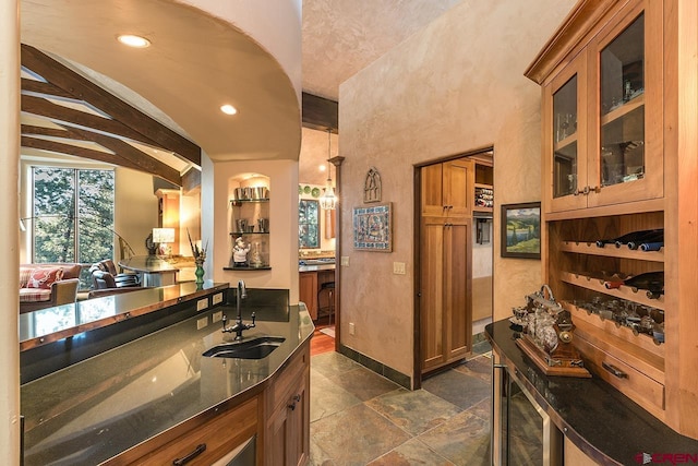 kitchen with sink and vaulted ceiling with beams