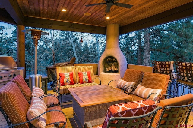 view of patio / terrace with area for grilling, ceiling fan, and an outdoor living space with a fireplace