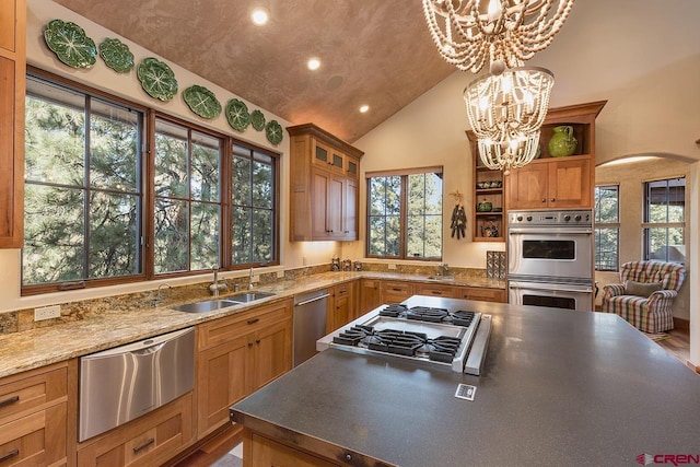 kitchen featuring sink, hanging light fixtures, stainless steel appliances, a notable chandelier, and vaulted ceiling