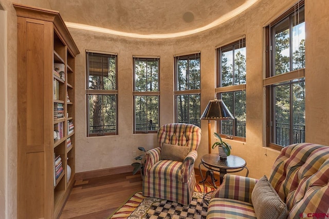 sitting room with hardwood / wood-style floors and a high ceiling