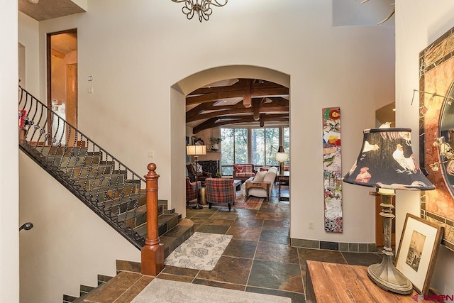 entryway with a high ceiling and beam ceiling