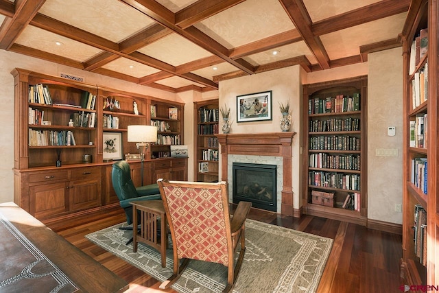 sitting room featuring built in features, a fireplace, dark hardwood / wood-style flooring, coffered ceiling, and beam ceiling