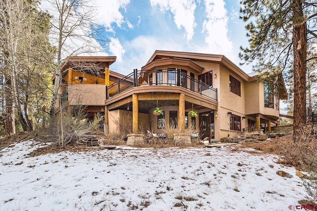 snow covered property featuring a balcony