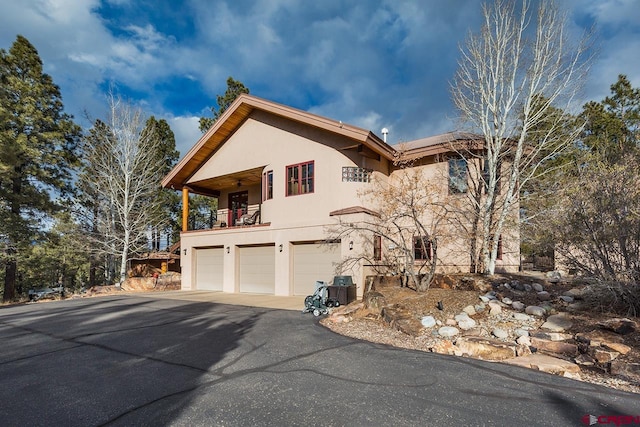 view of front of property featuring a garage and a balcony